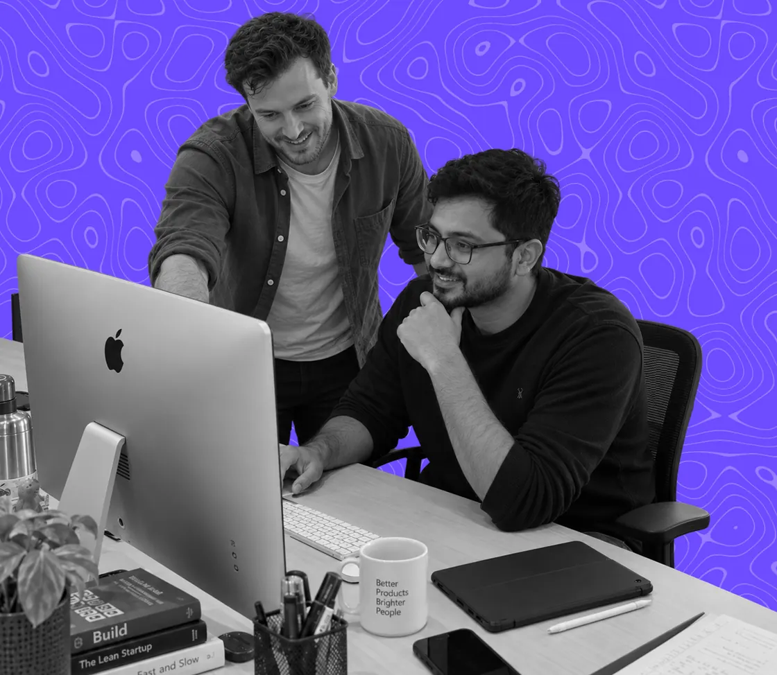 Two colleagues reviewing work together at a desk